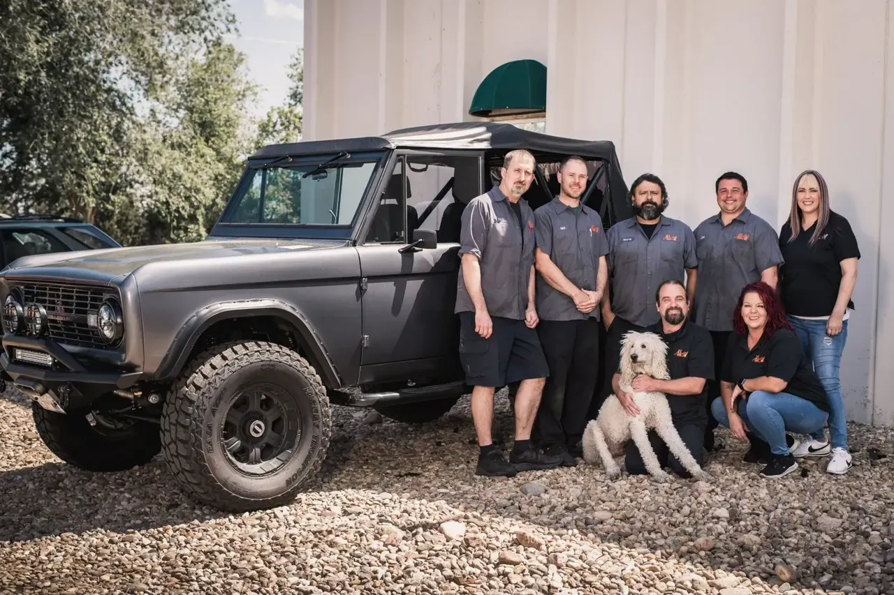 The Legacy Automotive team in Boulder, Colorado, standing with a custom Ford Bronco